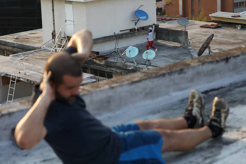 Каракас, Венесуэла. Люди занимаются фитнесом на крышах во время карантина