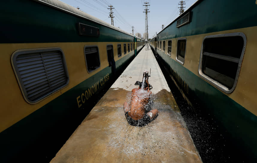 Карачи, Пакистан. Железнодорожный рабочий пытается освежиться во время жары
