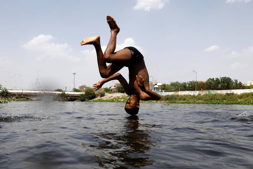 Нью-Дели, Индия. Парень прыгает в канал во время жары