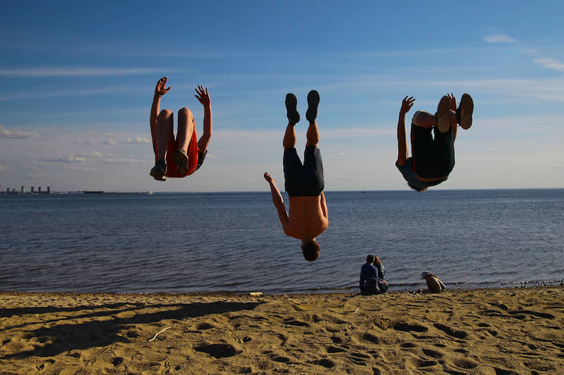 24 мая. Санкт-Петербург. Молодые люди прыгают на пляже в парке