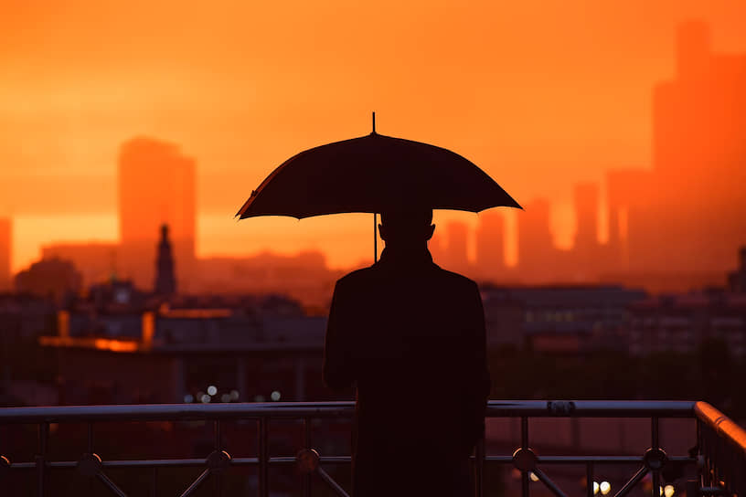 14 мая. Силуэт мужчины с зонтом на фоне закатного неба