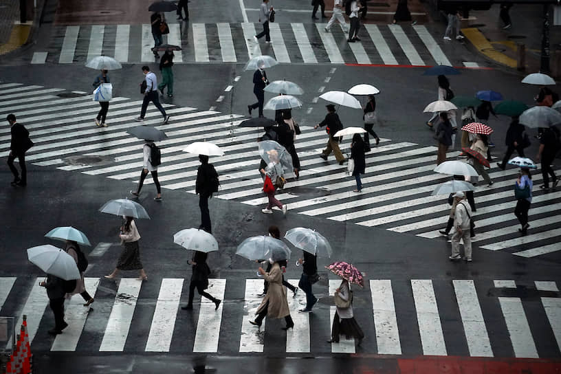 Токио, Япония. Люди идут по пешеходному переходу 
