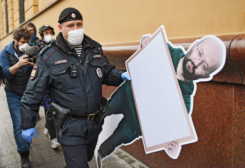 Москва. Сотрудники полиции уносят картонную фигуру журналиста Ильи Азара, арестованного после одиночного пикета