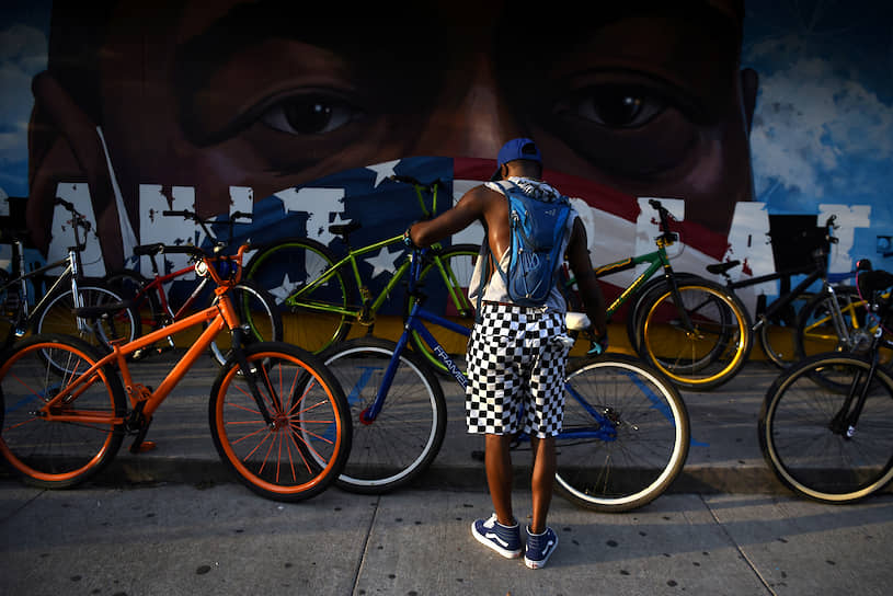Хьюстон, США. Мужчина паркует свой велосипед у стены с граффити, на котором изображен погибший после задержания Джордж Флойд 