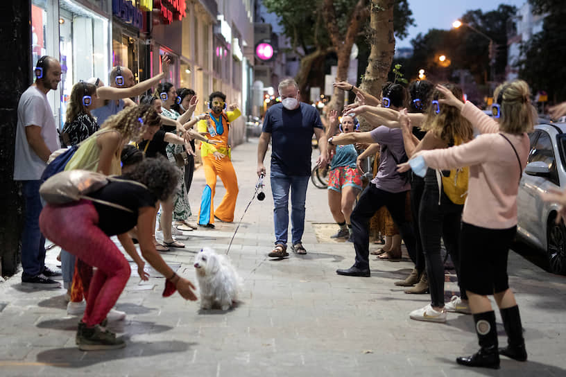 Тель-Авив, Израиль. Мужчина проходит мимо танцующих людей