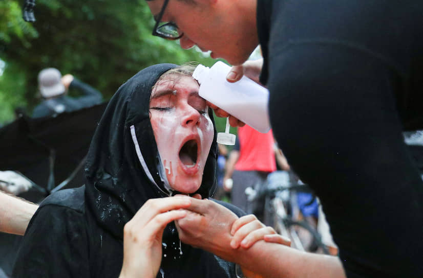 Вашингтон, США. Участник акции против расизма помогает женщине, которой полицейские попали в глаза перцовым спреем