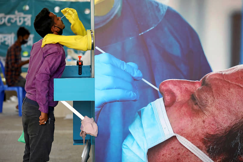 Дакка, Бангладеш. Медработник берет мазок для теста на коронавирус 