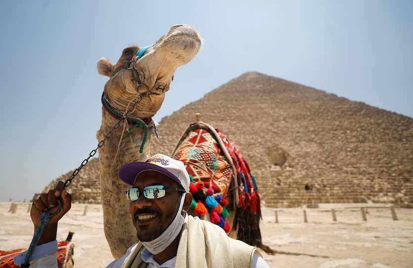 Каир, Египет. Мужчина с верблюдом на фоне пирамиды