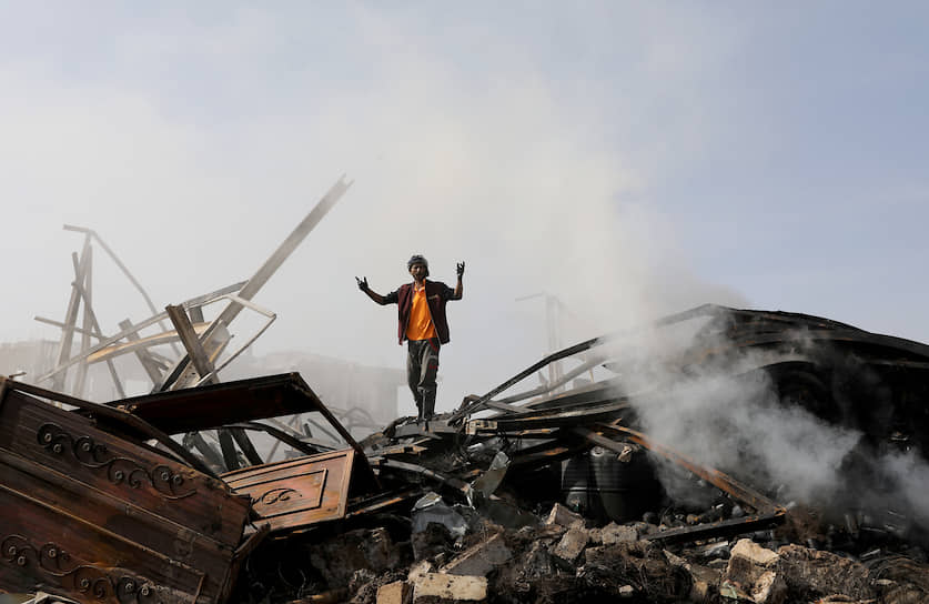 Сана, Йемен. Рабочий на обломках магазина, разрушенного авиаударом 