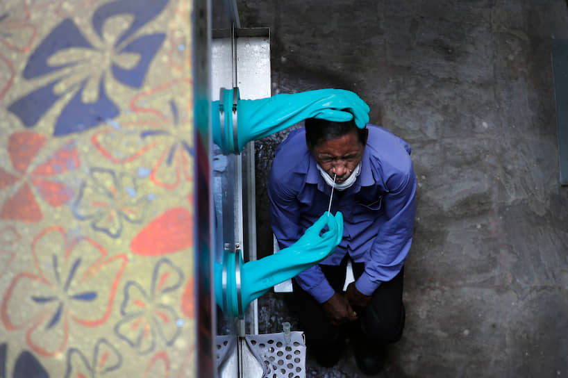 Нью-Дели, Индия. Медработник берет мазок для теста на коронавирус
