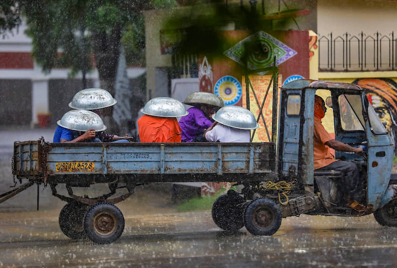 Праяградж, Индия. Местные жители укрываются от дождя 