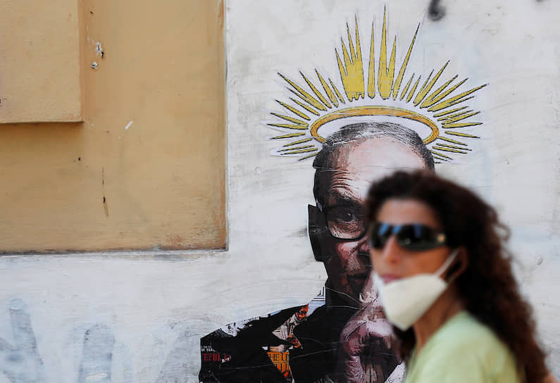 Рим, Италия. Женщина идет мимо граффити, сделанного в память о погибшем композиторе Эннио Морриконе 