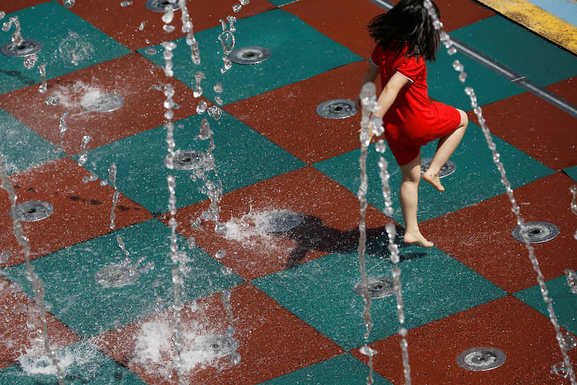 Пекин, Китай. Девочка играет возле фонтана