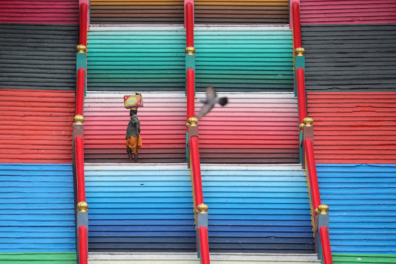 Куала-Лумпур, Малайзия. Мужчина поднимается по лестнице, ведущей в пещеры Бату
