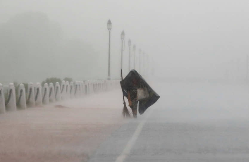 Нью-Дели, Индия. Женщина пытается укрыться от дождя 