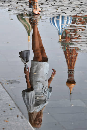 Москва. Отражение в воде женщины, идущей по Красной площади 