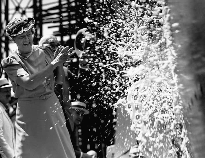 Перед спуском на воду нового корабля проводят специальный ритуал — о его борт разбивают бутылку шампанского&lt;br>
На фото: супруга президента США Элеонора Рузвельт разбивает бутылку шампанского о нос корабля S.S. America, 1939 год