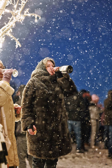 Люди пьют шампанское на смотровой площадке на Воробьевых горах в новогоднюю ночь