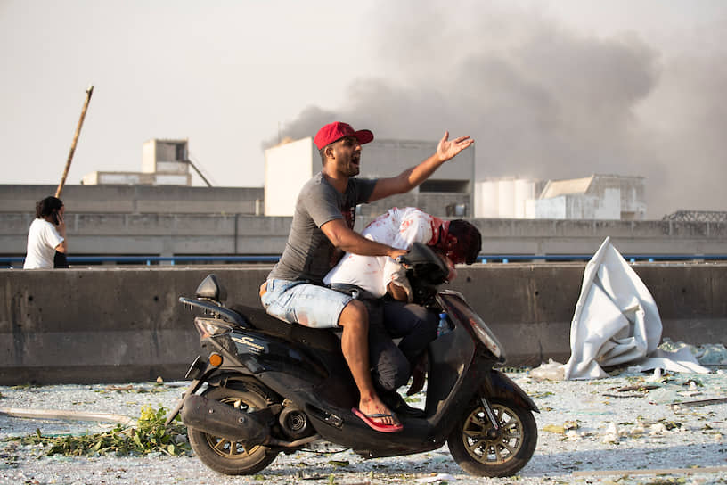 Бейрут, Ливан. Мужчина эвакуирует пострадавшего от взрыва в порту