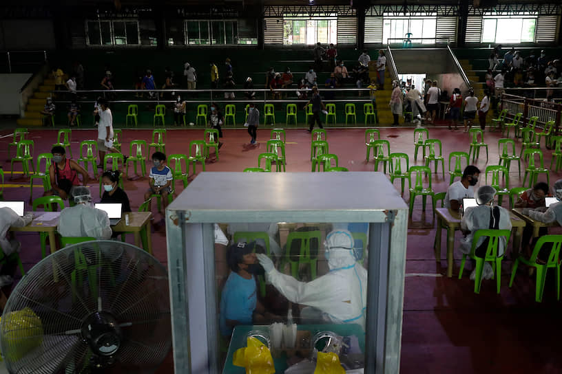 Навотас, Филиппины. Медработник делает тест на коронавирус
