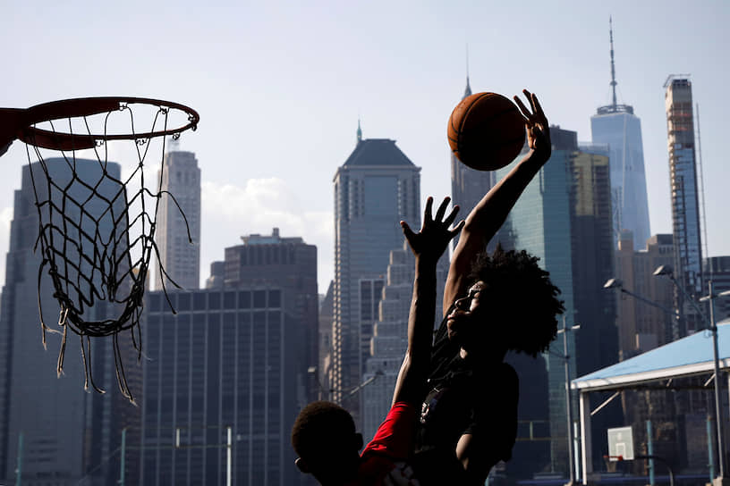 Нью-Йорк, США. Молодые люди играют в баскетбол 