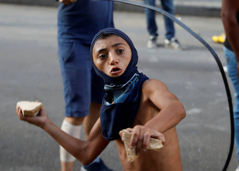 Бейрут, Ливан. Участник протестной акции бросает камень в полицейских