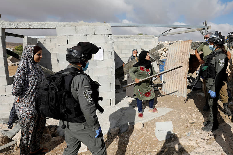 Сусия, Израиль. Палестинская женщина спорит с израильскими пограничниками, которые пытаются заставить ее прекратить строительство дома