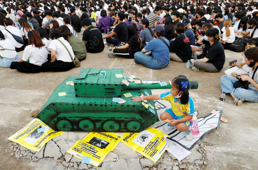 Бангкок, Таиланд. Дети клеят записки на бумажный танк во время собрания молодых демократов 