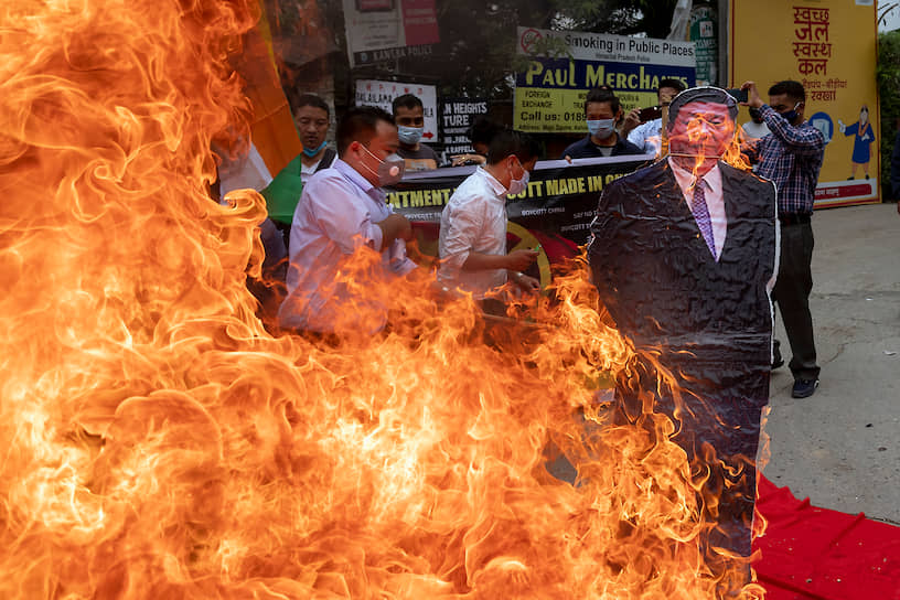 Представители Тибетского молодежного конгресса сжигают изображение председателя КНР Си Цзиньпиня во время уличной акции против засилья китайских товаров