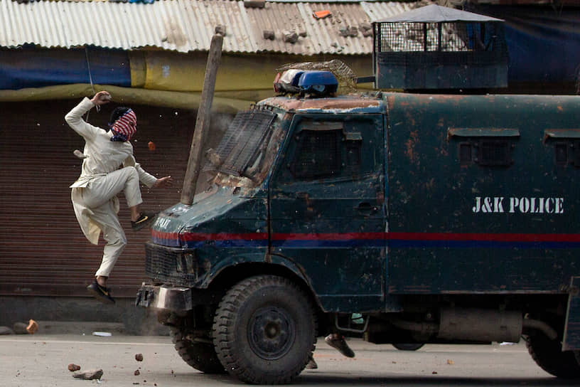 Протестующий нападает на полицейскую машину в Сринагаре (Кашмир)  
