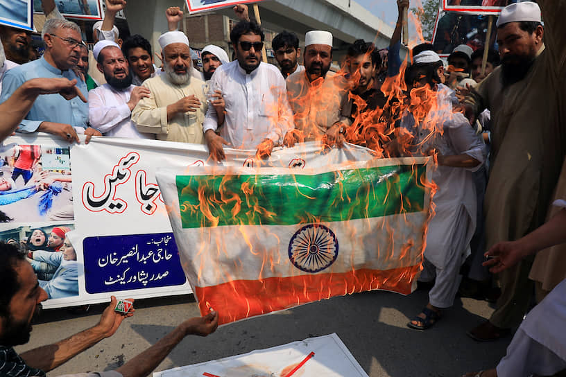 Участники акции солидарности с Кашмиром в пакистанском Пешаваре сжигают индийский флаг 