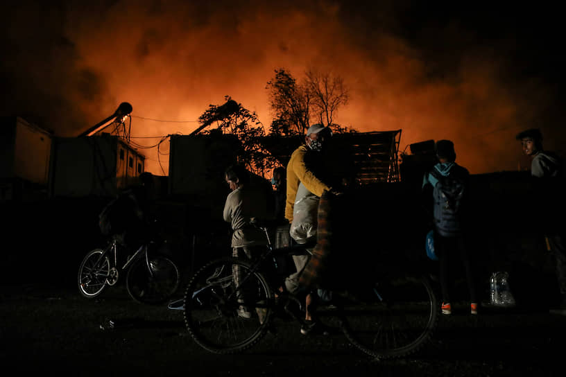 Лесбос, Греция. Мигранты бегут со своими вещами из лагеря беженцев, охваченного пожаром 