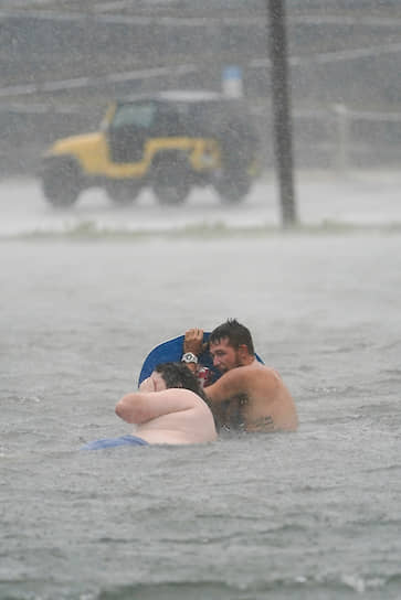 Пенсакола, штат Флорида, США. Люди на затопленной парковке у пляжа Наварр 