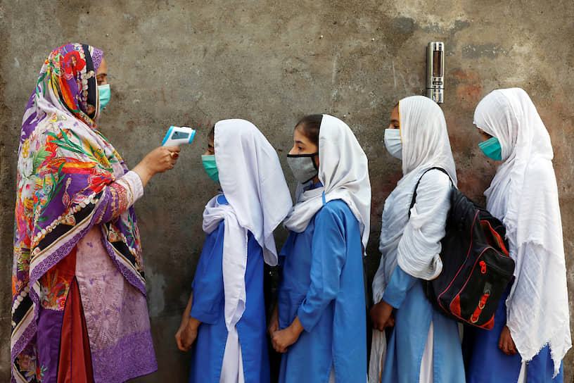 Пешавар, Пакистан. Измерение температуры тела учениц перед входом в школу