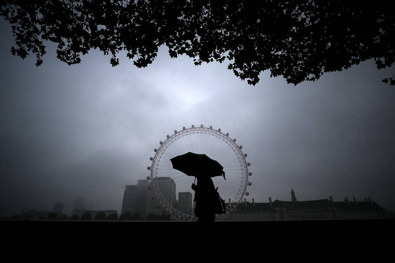 Лондон, Великобритания. Мужчина на фоне колеса обозрения «Лондонский глаз»