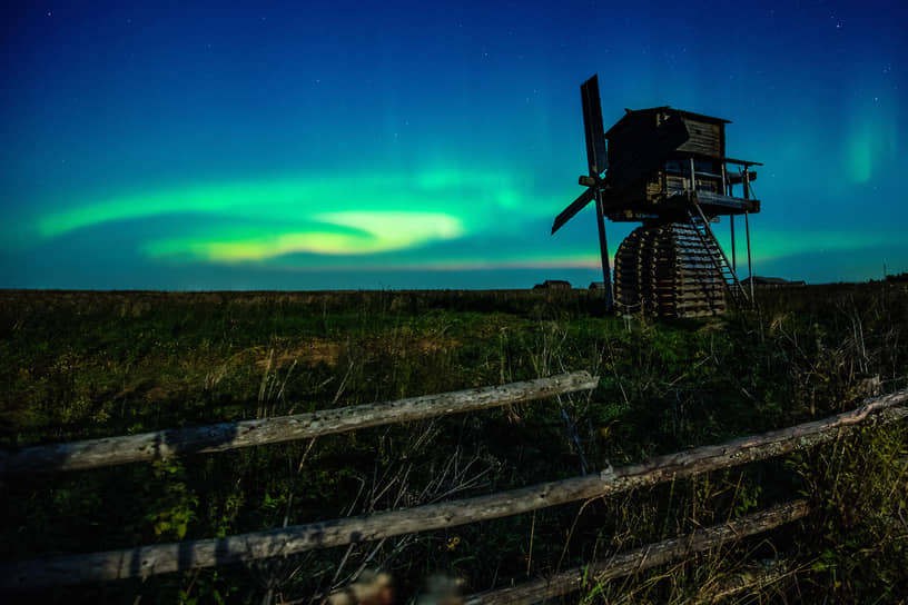 Деревня Кимжа, Архангельская область, Россия. Ветряная мельница на фоне северного сияния