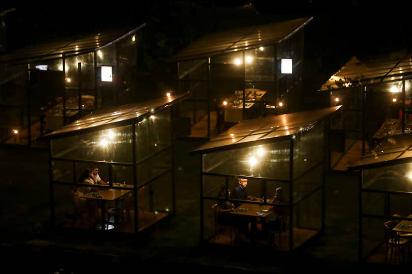 Рио-де-Жанейро, Бразилия. Люди сидят в ресторане в специально оборудованных кабинках 