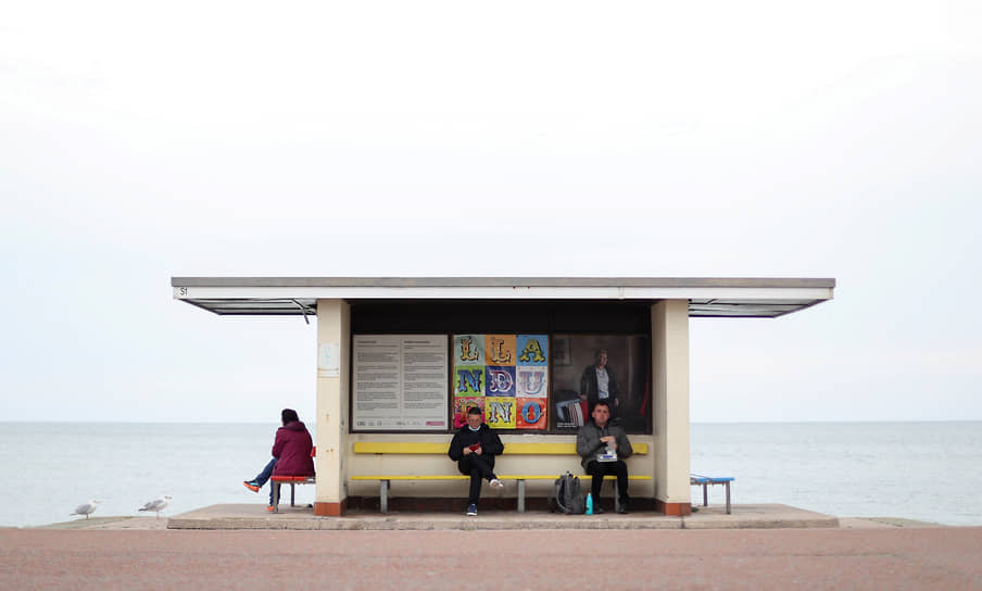 Лландидно, Великобритания. Люди ждут на автобусной остановке в Уэльсе