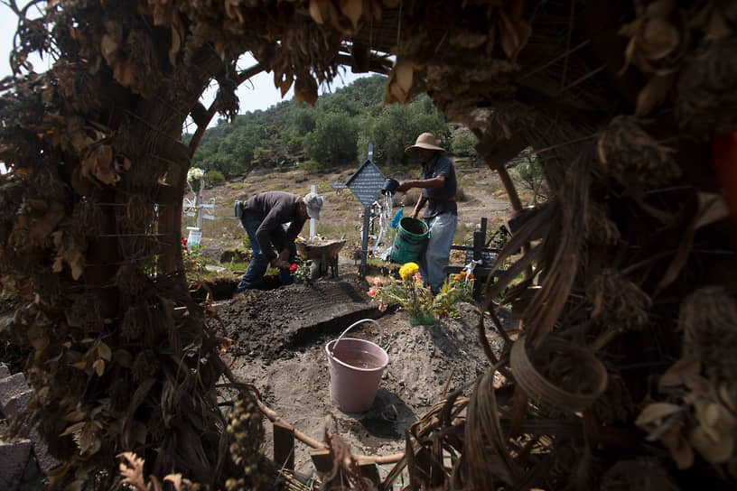 Мехико, Мексика. Рабочие на кладбище на окраине города