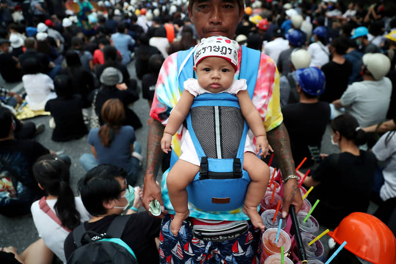Бангкок, Таиланд. Мужчина с ребенком продает прохладительные напитки во время акций протеста