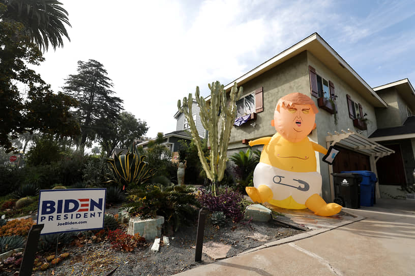 Надувная кукла в виде президента США Дональда Трампа перед одним из домов с табличкой «Байдена в президенты» в Лос-Анджелесе (Калифорния)