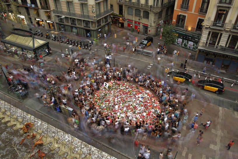 Люди приносят цветы на место теракта в Барселоне 19 августа 2017 года