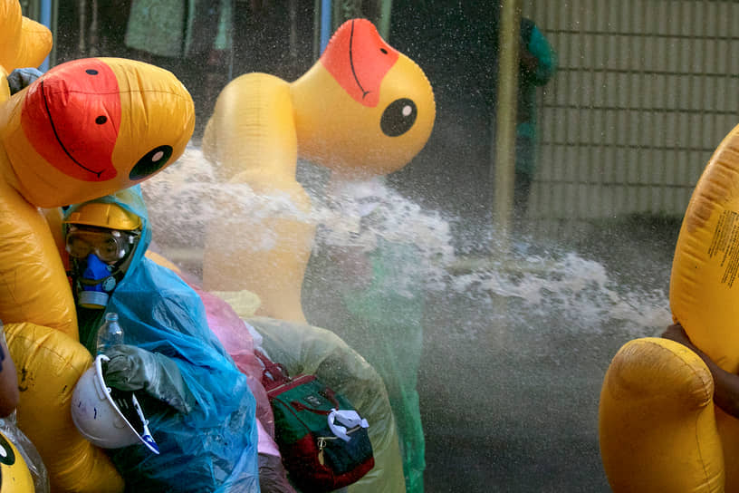 Бангкок, Таиланд. Протестующие укрываются от водометов за надувными утками 