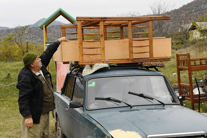 Житель села Карегах грузит на багажник автомобиля мебель из своего дома