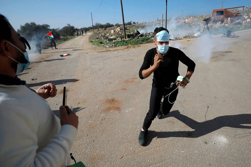 Сальфит, Западный берег реки Иордан. Палестинский демонстрант убегает от израильских силовиков, кинувших гранату со слезоточивым газом