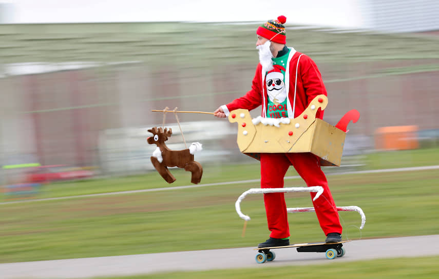 Берлин, Германия. Человек в костюме Санта-Клауса катается на электрическом скейтборде