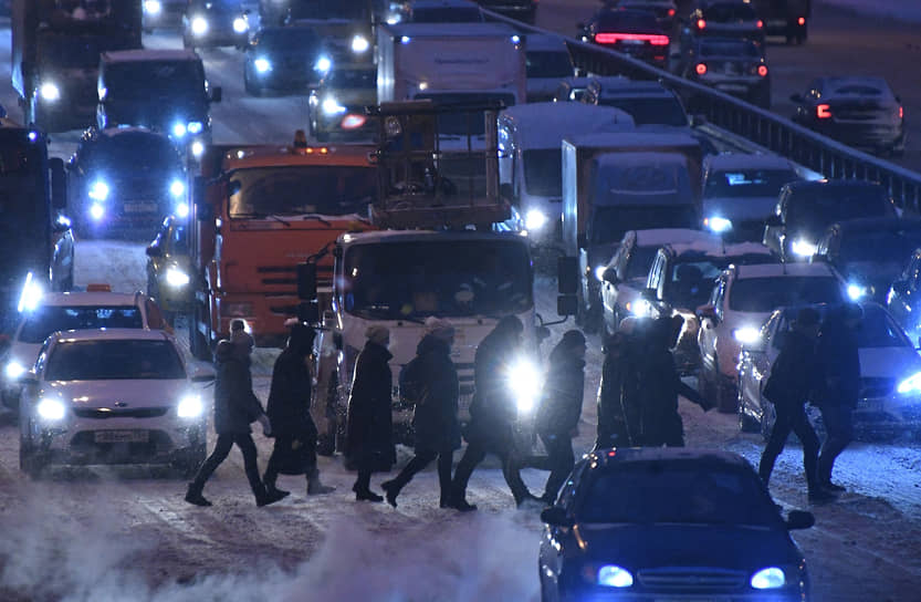 Москва, Россия. Автомобили и пешеходы во время снегопада 