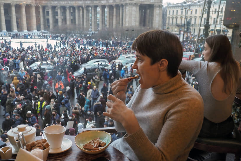 Посетители кафе наблюдают за митингом в Санкт-Петербурге