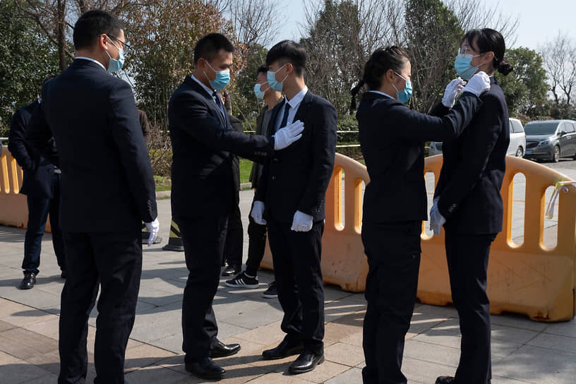 Ухань, Китай. Сотрудники отеля перед началом пресс-конференции Всемирной организации здравоохранения  