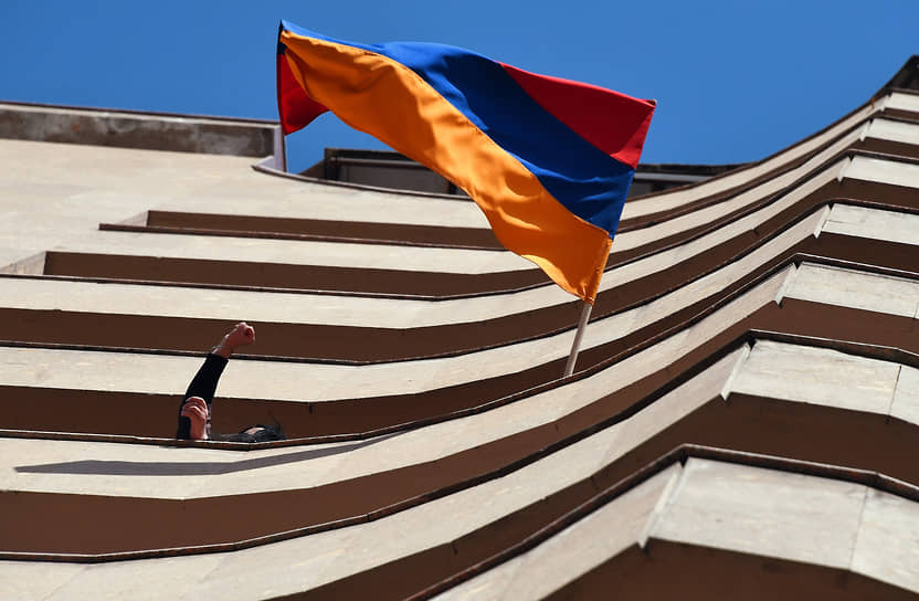 Ереван, Армения. Жители на балконе дома с государственным флагом во время митингов